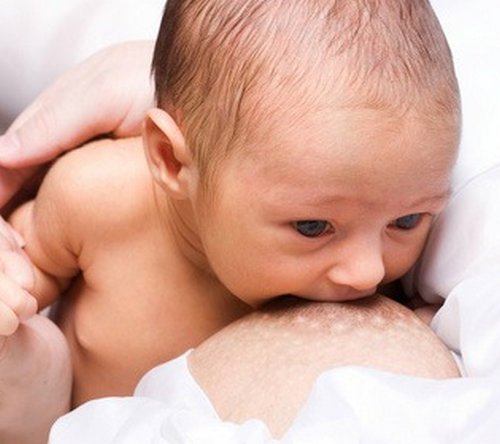 A mom breastfeeding her newborn.image